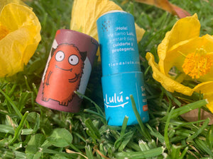 Balsamo barra carton abierto en pasto con fondo flores amarillas