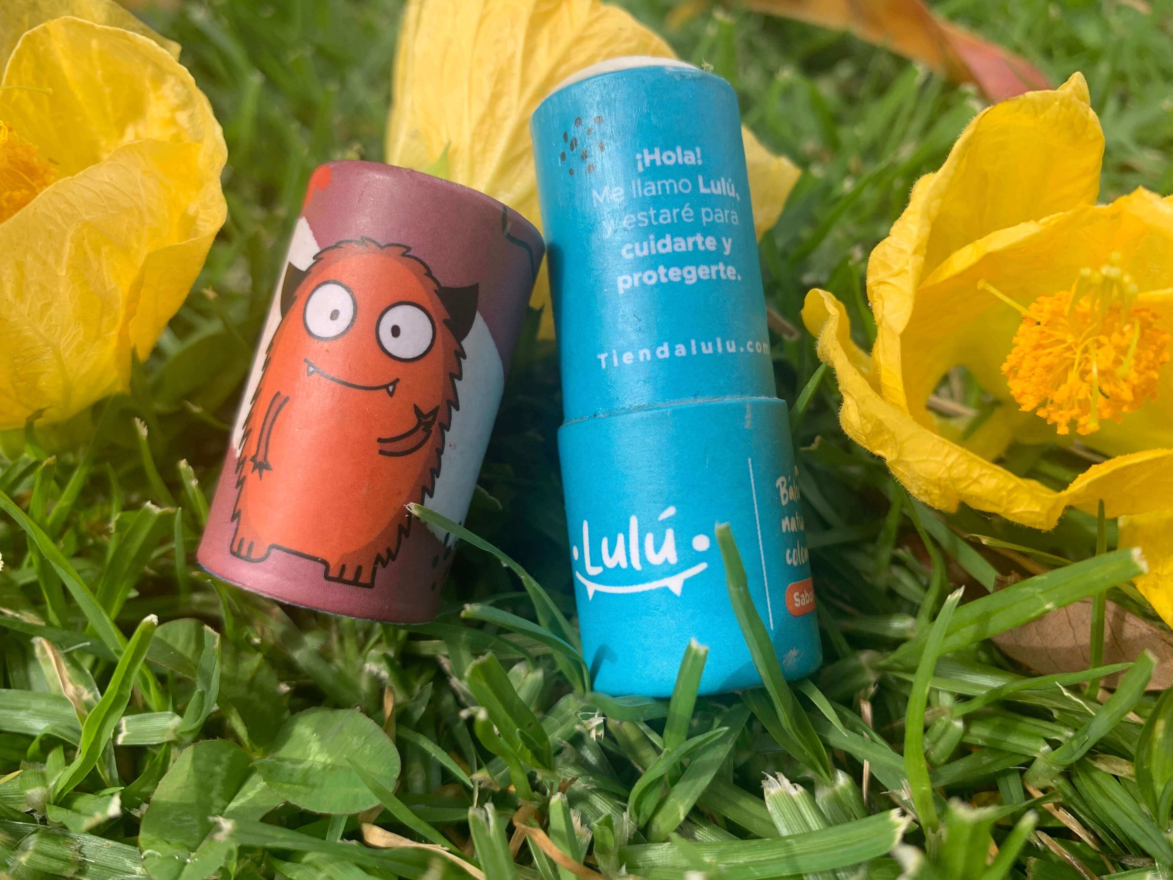 Balsamo barra carton abierto en pasto con fondo flores amarillas