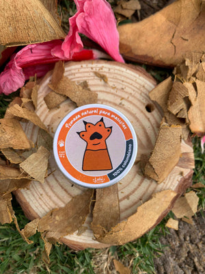 Pomada para mascotas sobre trozo de madera y hojas