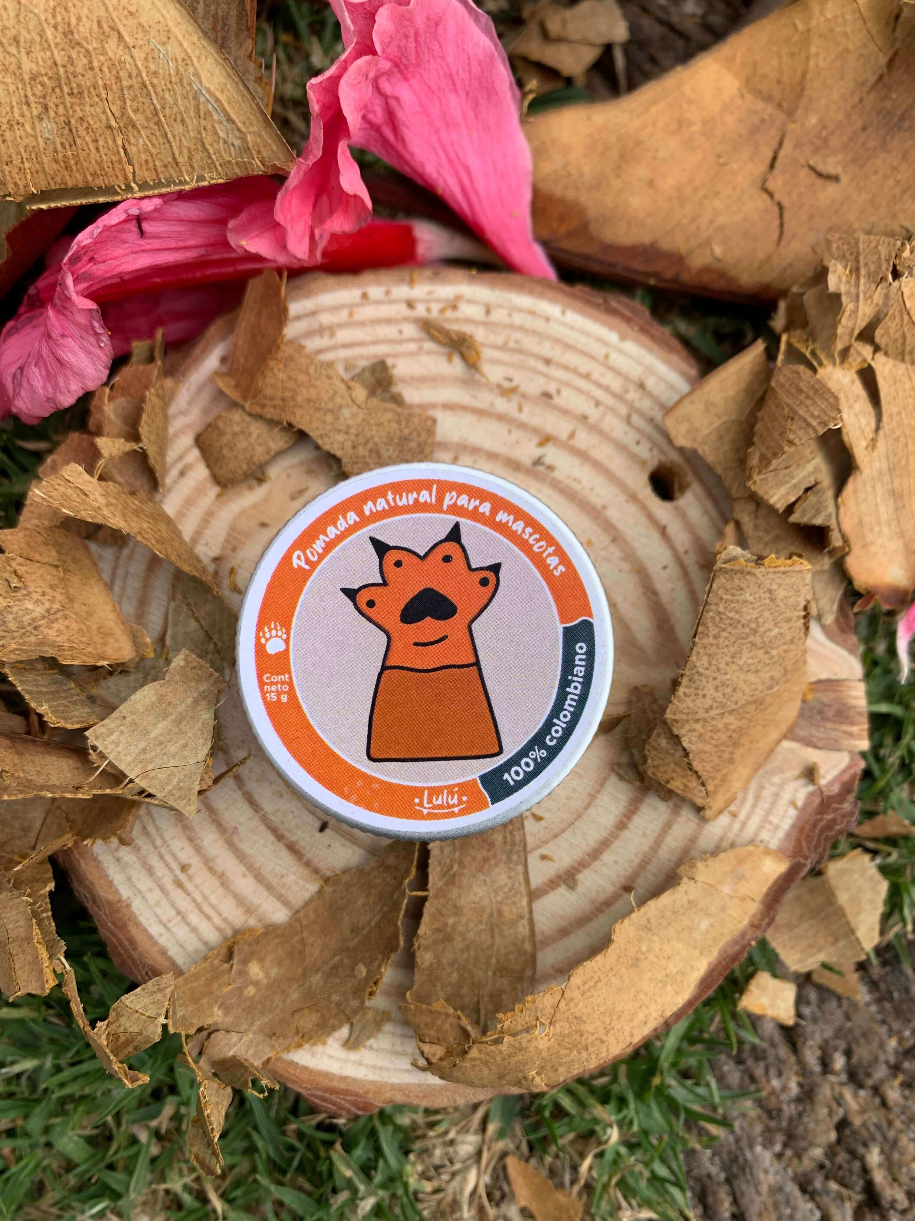 Pomada para mascotas sobre trozo de madera y hojas