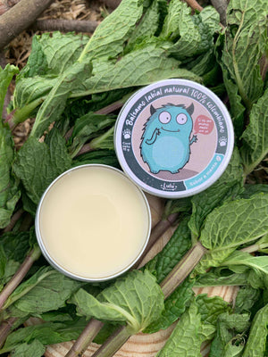 Bálsamo Menta en tarrito abierto sobre hojas de menta