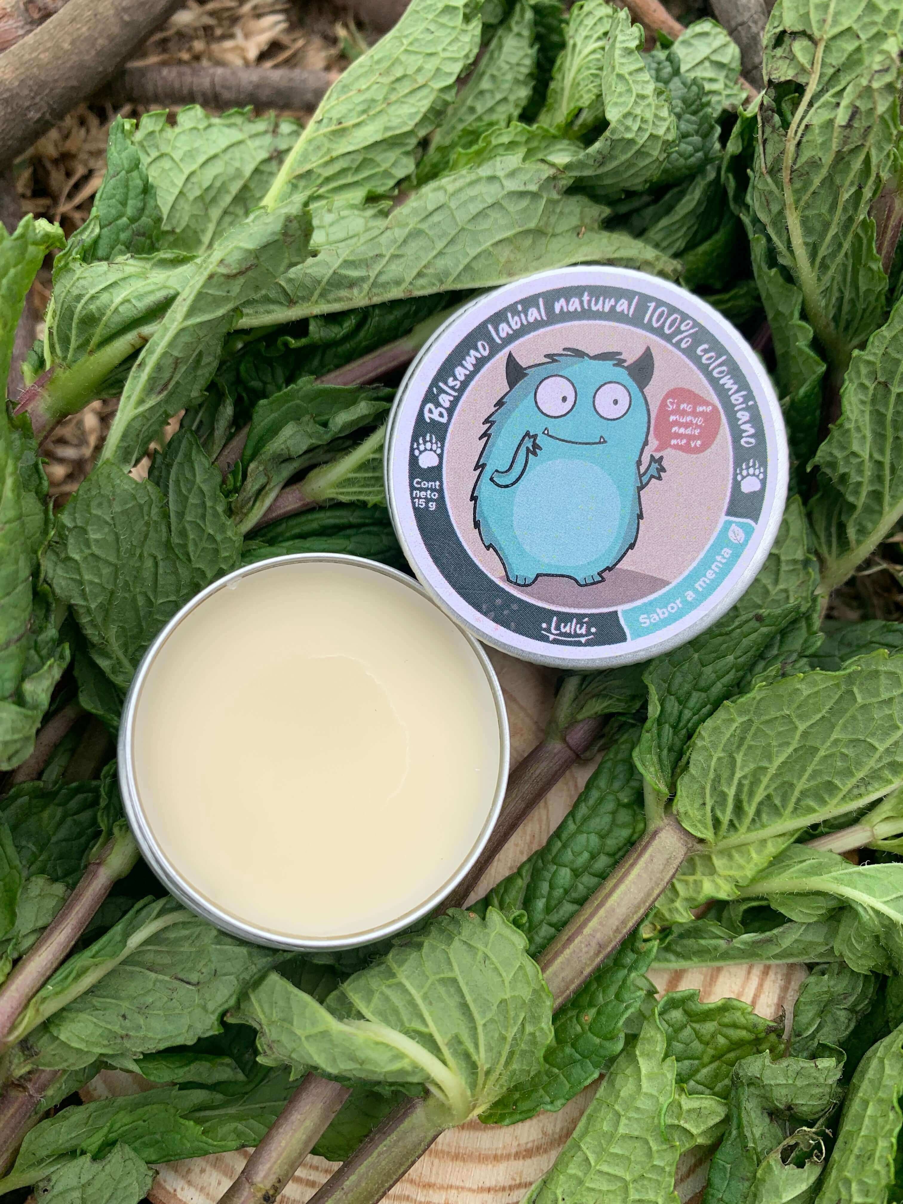 Bálsamo Menta en tarrito abierto sobre hojas de menta